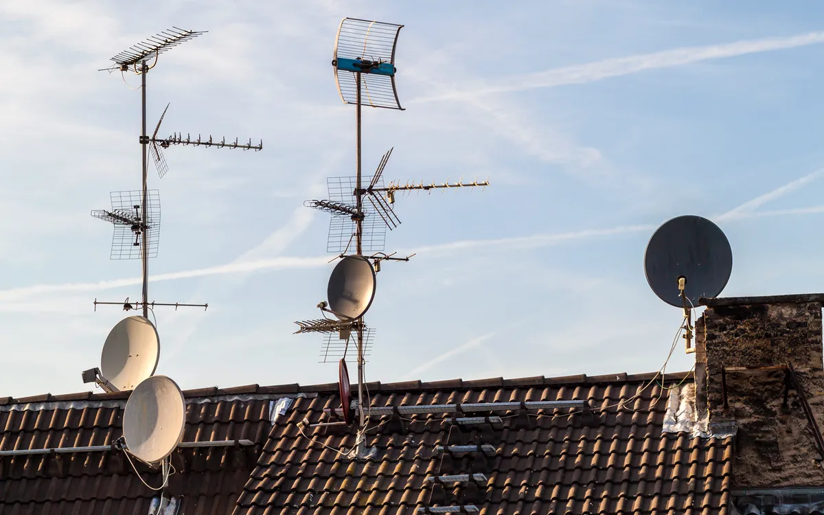 Antennes rateaux et paraboles installees sur une toiture en tuiles