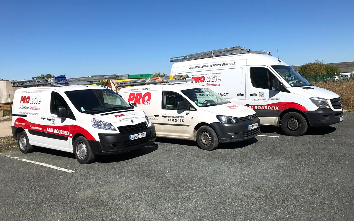Les trois utilitaires floques de la SARL Bourdeix alignes devant le depot, sous un ciel bleu