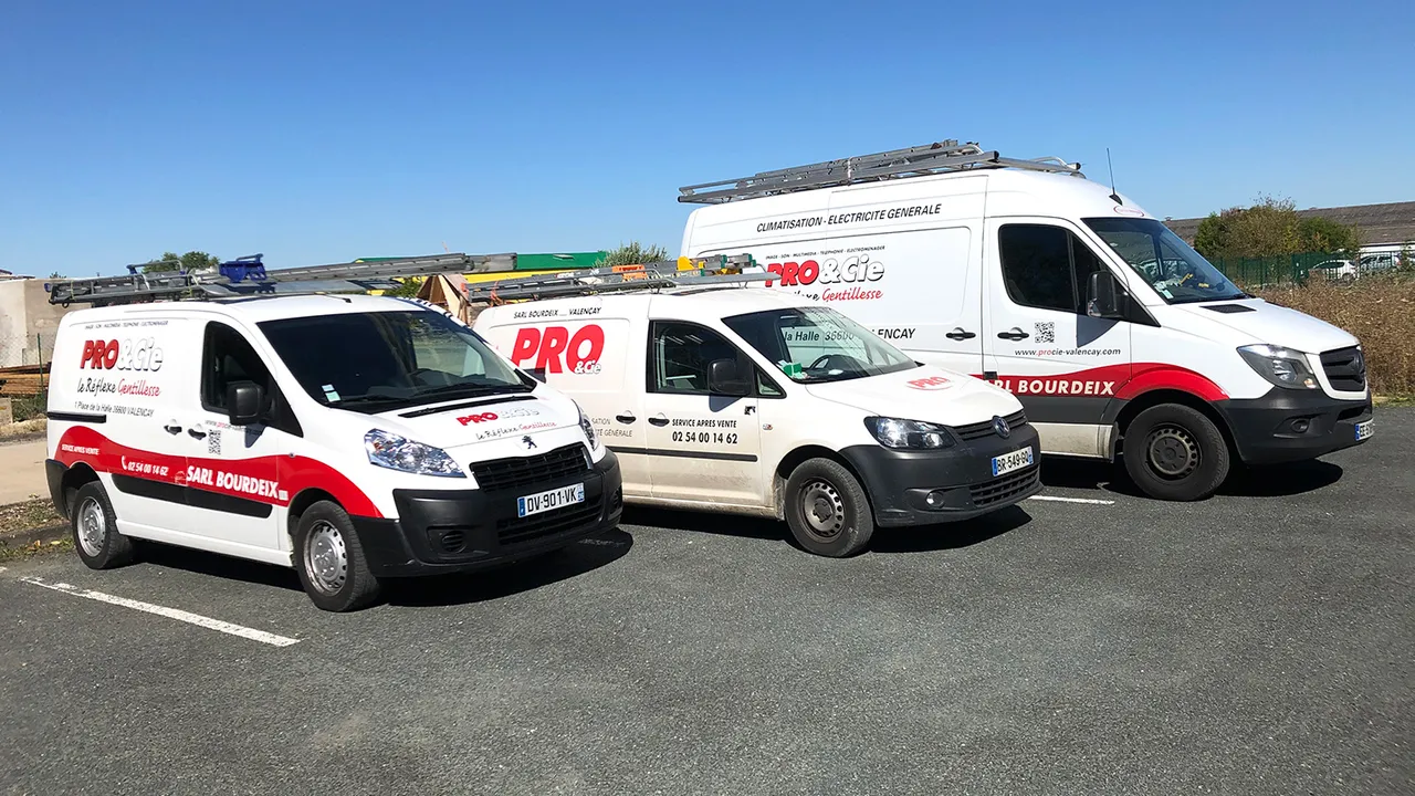 Les trois utilitaires floques de la SARL Bourdeix alignes devant le depot, sous un ciel bleu